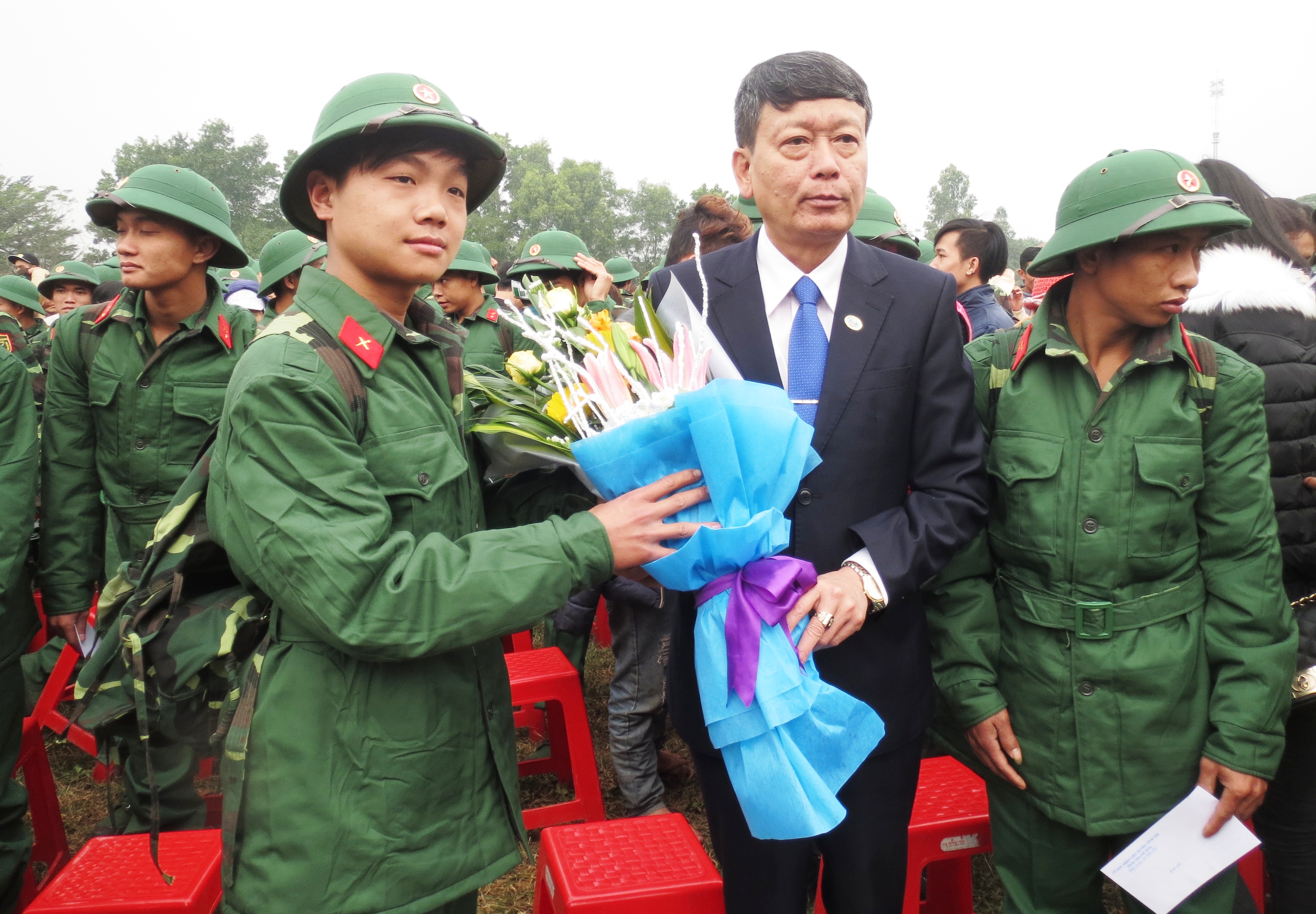 Đồng chí Nguyễn Xuân Thủy, Tỉnh ủy viên, Bí thư Huyện ủy tặng hoa cho các tân binh.